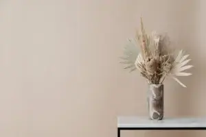 Neutral dried floral arrangement in marble vase on minimalist table